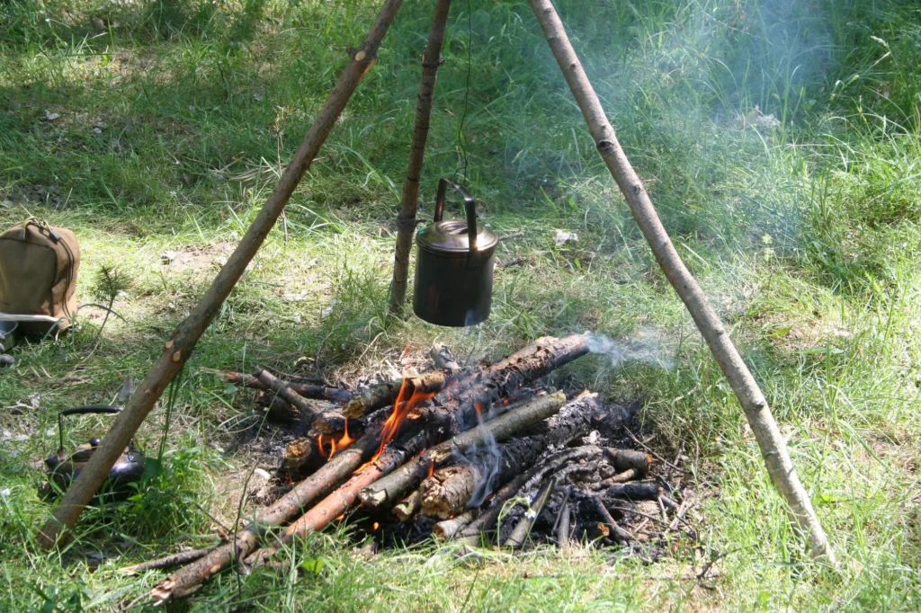 Ognisko z trójnogiem i kociołkiem w lesie